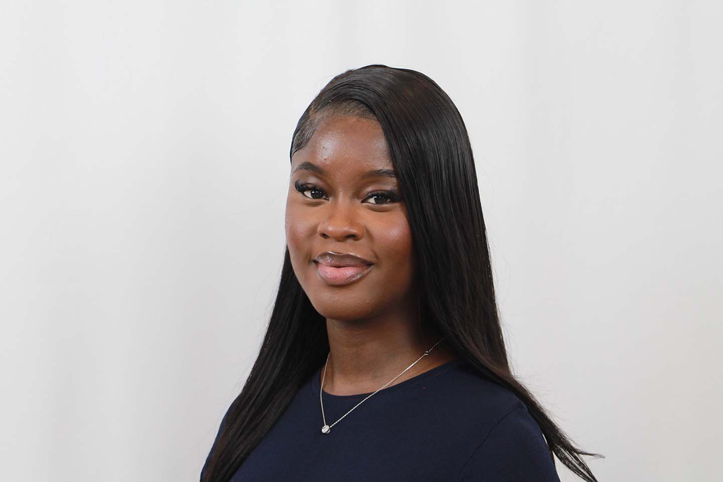 Headshot of Debra Olaniyi, with a grey background