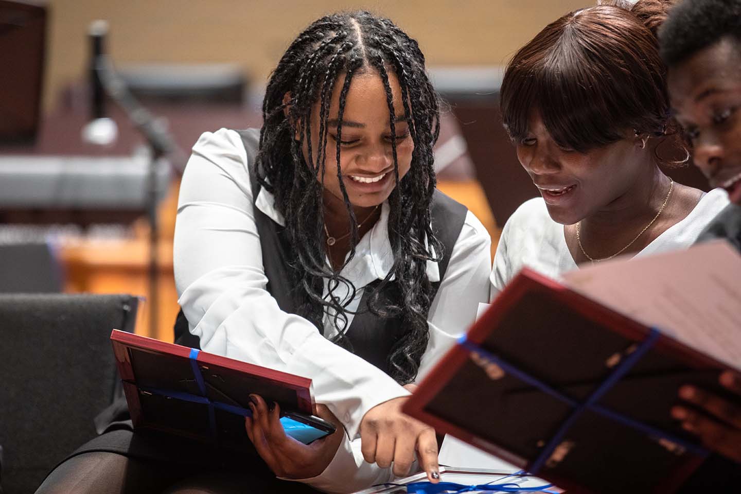 Graduates look at their certificates during the SEE @ UTM celebration and graduation at the H.J.A. Brown Education Centre in Mississauga.